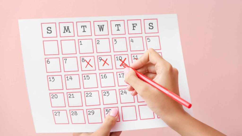  A close-up of a calendar with several dates marked in red.
