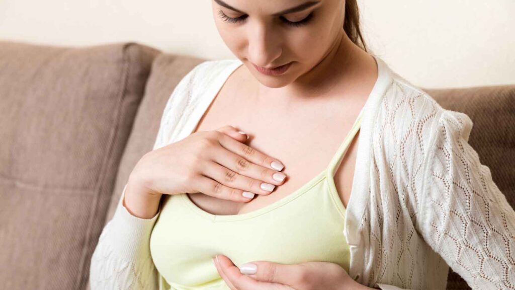 Woman placing her hand on her chest, appearing concerned. 