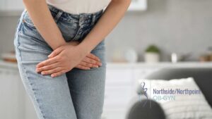 Woman holding her lower stomach while standing