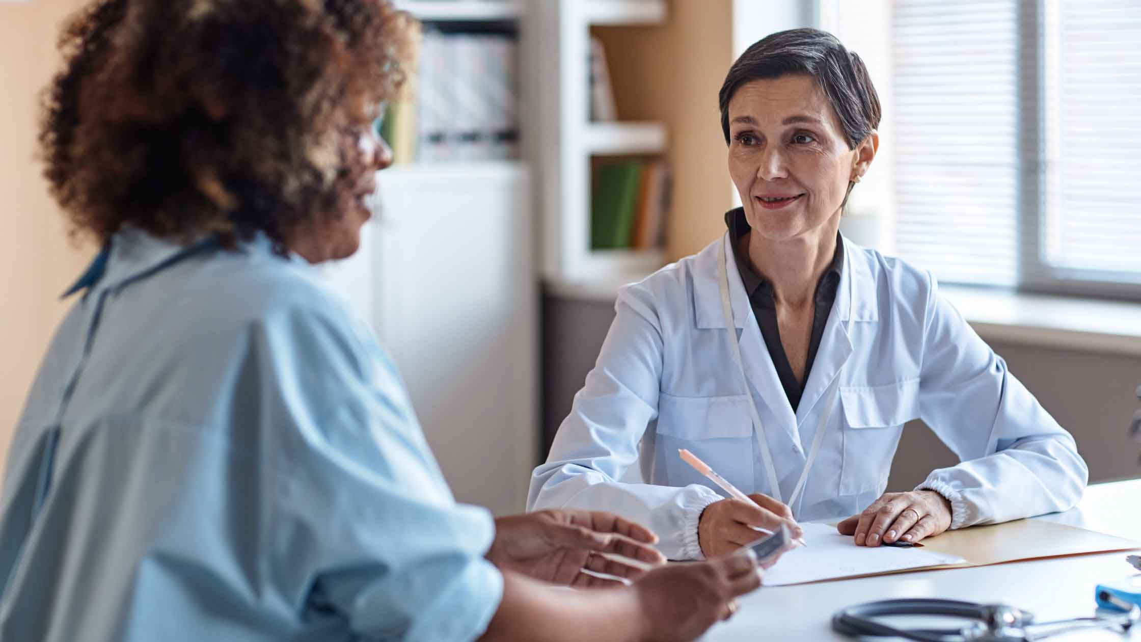 Woman sitting across from an OBGYN doctor
